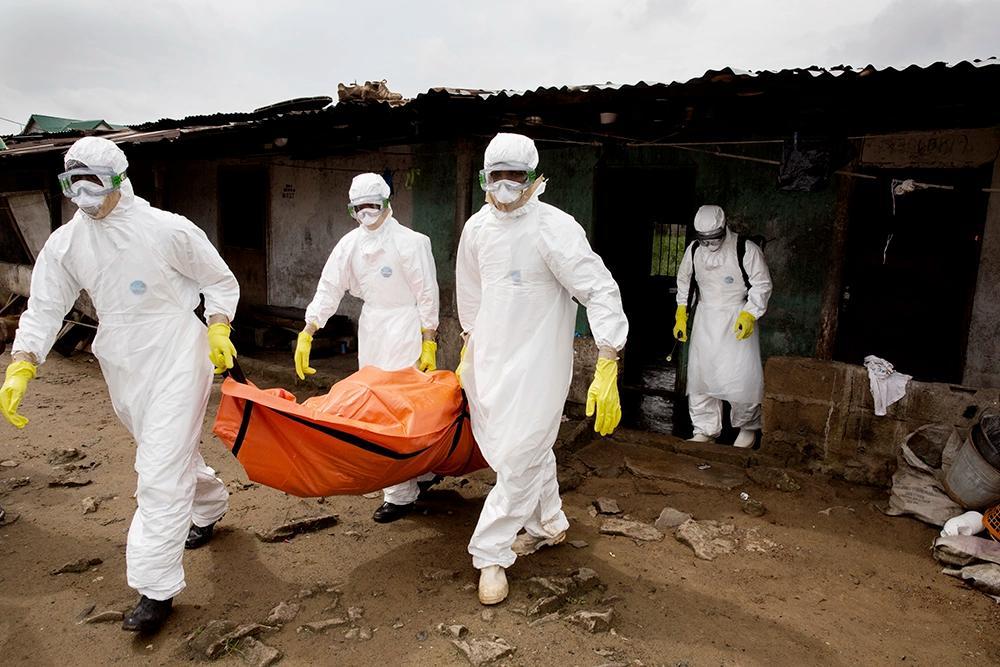 Person i skyddskläder bär avliden i ebola